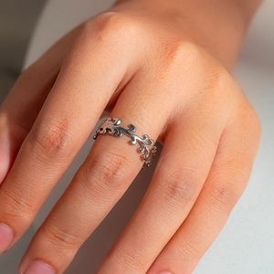 Close-up of a silver vintage filigree hollow scroll pattern ring worn on a hand