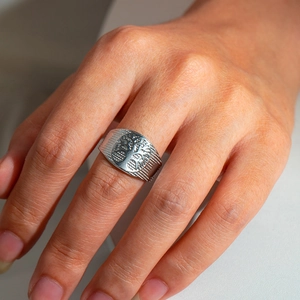 Detail of silver stainless steel wide ring featuring engraved Tree of Life pattern and texture