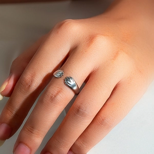 Detailed view of adjustable cat paw open ring in polished silver finish on finger