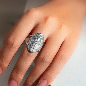 Macro shot of silver oval boho ring with intricate dotted texture on finger