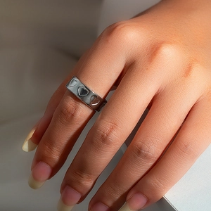 Close-up of a minimalist hollow heart pattern ring in polished silver stainless steel