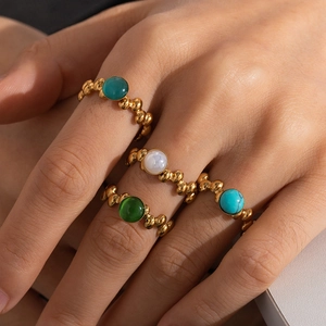 Detailed macro view of four vintage bohemian rings with colorful gemstones in gold finish