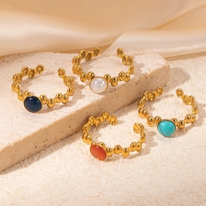 Macro detail of four 18K gold plated vintage rings with colorful round gemstone inlays
