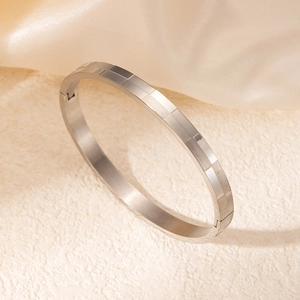 Vue détaillée d'un bracelet en acier inoxydable argenté avec motif de grille géométrique