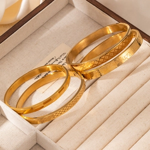 Set de cuatro brazaletes de acero inoxidable bañados en oro de 18k con diseños grabados