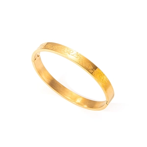 Detalle de brazalete chapado en oro 18k con grabados de rosas y vides finas