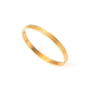 Detalle de brazalete de acero inoxidable dorado con textura de cuadrícula clásica