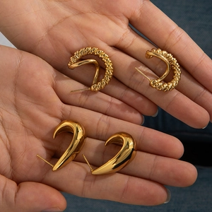 Détails de boucles d'oreilles vintage dorées avec texture torsadée et design incurvé lisse