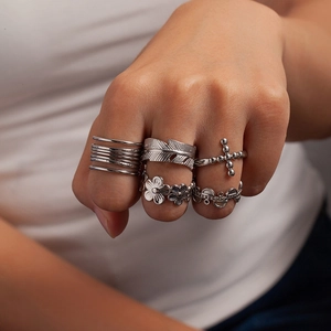 Dettaglio di un set di cinque anelli d'argento vintage su mani di modella con vari motivi