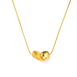 Detail of minimalist gold necklace with twisted Mobius pendant on a snake chain