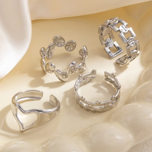 Dettaglio di quattro anelli in acciaio inossidabile argento con design a cuore e corona