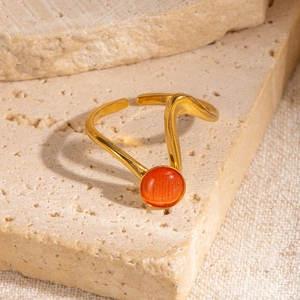 Dettaglio anello a onde in oro 18K con pietra naturale arancione su base in pietra