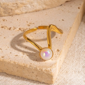 Dettaglio anello a onde placcato oro 18K con pietra bianca cangiante su base in pietra