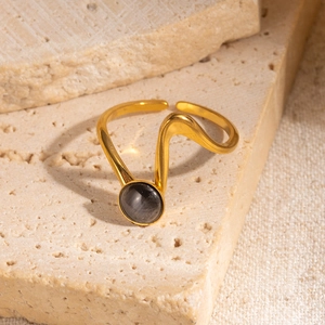 Dettaglio di un anello a onde placcato oro 18K con inserto di pietra grigia naturale