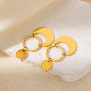 Dettaglio di orecchini a luna placcati in oro 18k su un supporto in pietra bianca