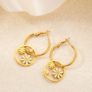 Dettaglio di orecchini a cerchio placcati oro 18k con margherite in smalto bianco