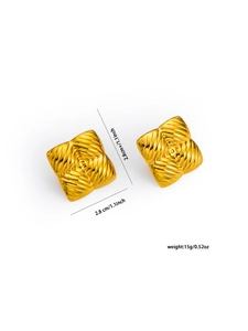 Dettaglio macro di orecchini dorati 18k con trama a piramide e misura 2,8 cm