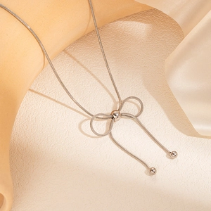 Dettaglio della collana a fiocco d'argento con nappe di perline e catena a serpente