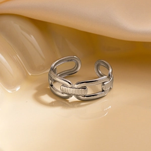 Gros plan sur la bague à maillons argentée avec gravures sur support céramique