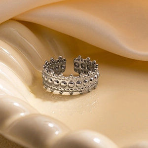 Détail d'une bague en acier avec points en relief sur un plateau en céramique