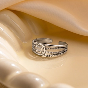 Détail d'une bague ouverte en argent avec design à trois couches de perles et étoile