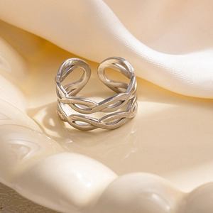 Dettaglio ravvicinato di un anello aperto in argento multistrato su vassoio in ceramica