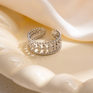 Dettaglio dell'anello regolabile in argento con motivo a foglie d'olivo su vassoio