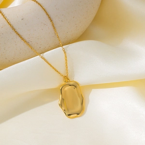Detail of 18K gold plated necklace featuring an irregular textured pendant on silk