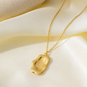 Elegant 18K gold-plated irregular lava pendant necklace displayed on silk fabric