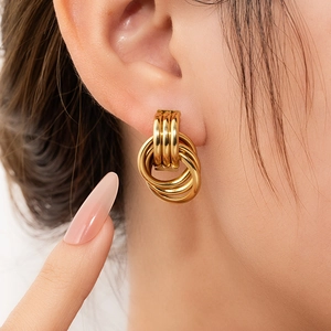 Minimalist gold-plated interlocking hoops earrings displayed on model for elegant look
