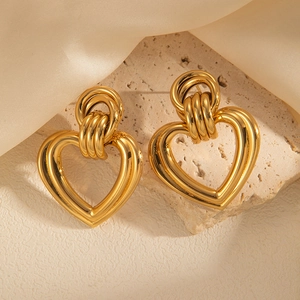 Vintage golden heart drop earrings on stone and champagne silk background
