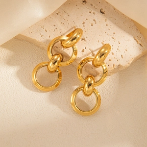 Macro shot of polished gold geometric interlocking chain rings on textured stone