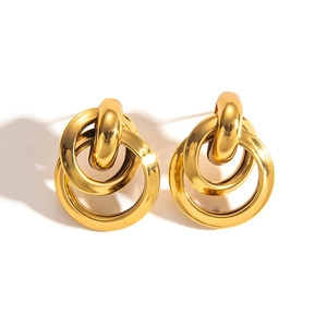 Macro detail of triple interlocking gold hoop earrings with mirror polished finish
