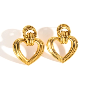 Detail of vintage gold heart earrings with twisted circular pattern and polished finish