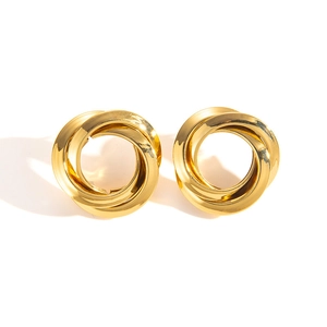 Close-up of golden geometric knotted hoop earrings with polished metallic mirror finish