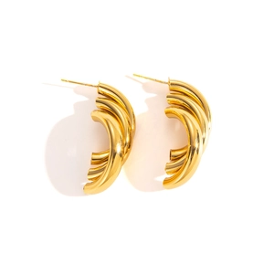 Detail of layered gold-plated C-shaped hoop earrings with a polished metallic finish