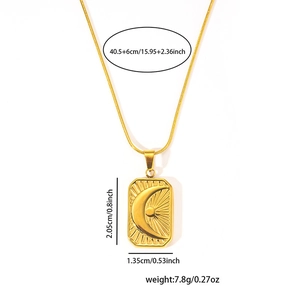 Detail view of gold celestial pendant with moon and sun engraving on fine link chain