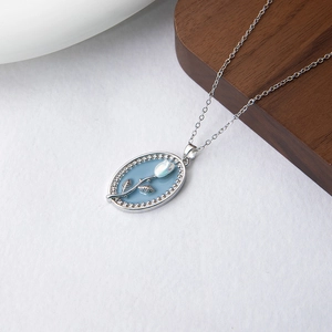 Vue détaillée du pendentif tulipe bleu clair en relief sur une fine chaîne argentée