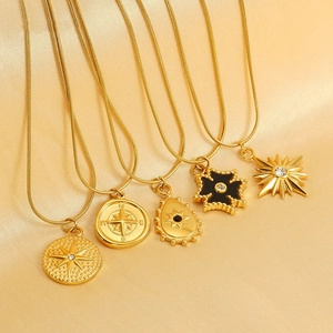 Set of five gold titanium steel necklaces with compass, star, and sunburst charms