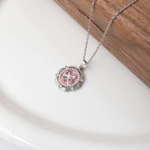 Détail macro du pendentif peinture à l'huile rose avec perle et émail rose sur chaîne argent