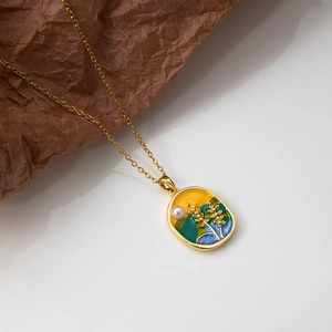 Détail d'un collier doré avec pendentif en émail paysage et petite perle d'eau douce