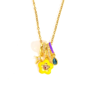 Detail of gold chain necklace with pink zircon heart, blue gemstone and yellow flower pendant