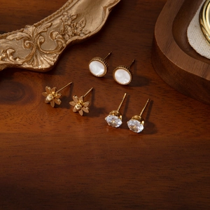 Trois paires de boucles d'oreilles élégantes en acier titane avec marguerites et zircons