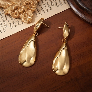 Elegantes pendientes de gota en acero de titanio dorado con diseño fluido pulido