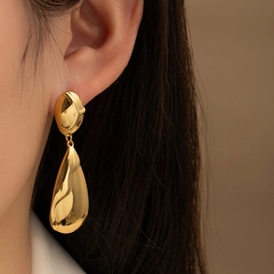 Pendientes de gota en titanio dorado pulido mostrados en un primer plano elegante