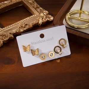 Trois paires de boucles d'oreilles dorées en acier avec papillon, chiffres romains et zircon