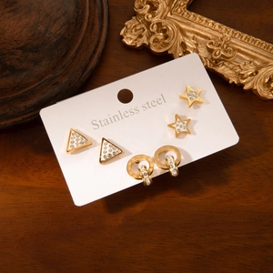 Lot de trois boucles d'oreilles en acier doré avec motifs étoile, triangle et romains