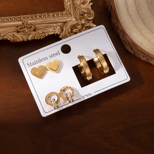 Parure de trois paires de boucles d'oreilles en acier doré avec chiffres romains