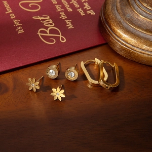 Three pairs of elegant gold titanium steel earrings featuring floral and Roman numeral designs