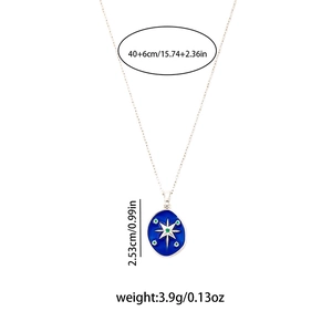 Detail showing the 2.53cm blue oval star pendant with green gems on a titanium chain